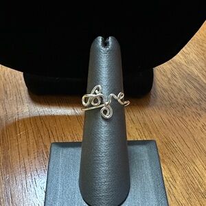 Handmade silver twist “love” ring that is adjustable.